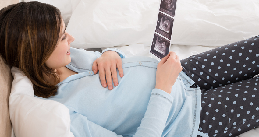 Stock image of a pregnant woman checking her scan report